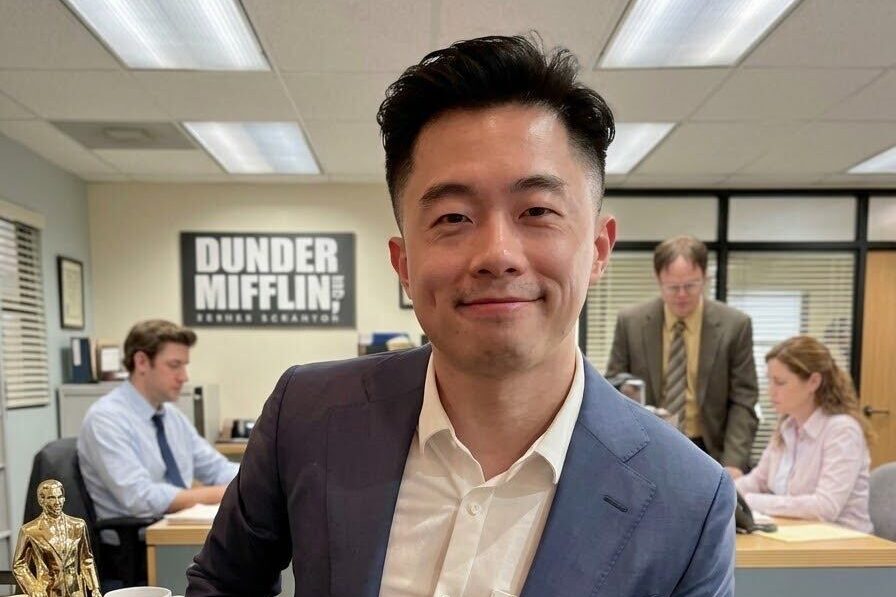 Jeff at a recreation of the Dunder Mifflin office, a Dundie Award on the desk beside him